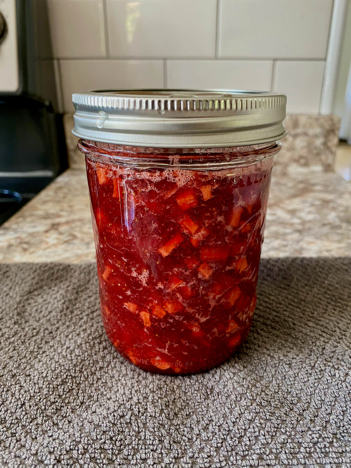 A preserved jar of strawberry apple jam.