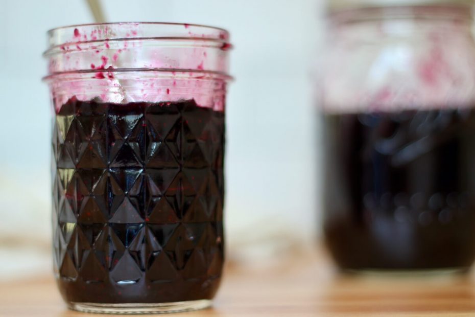 An open jar of homemade blueberry jam.