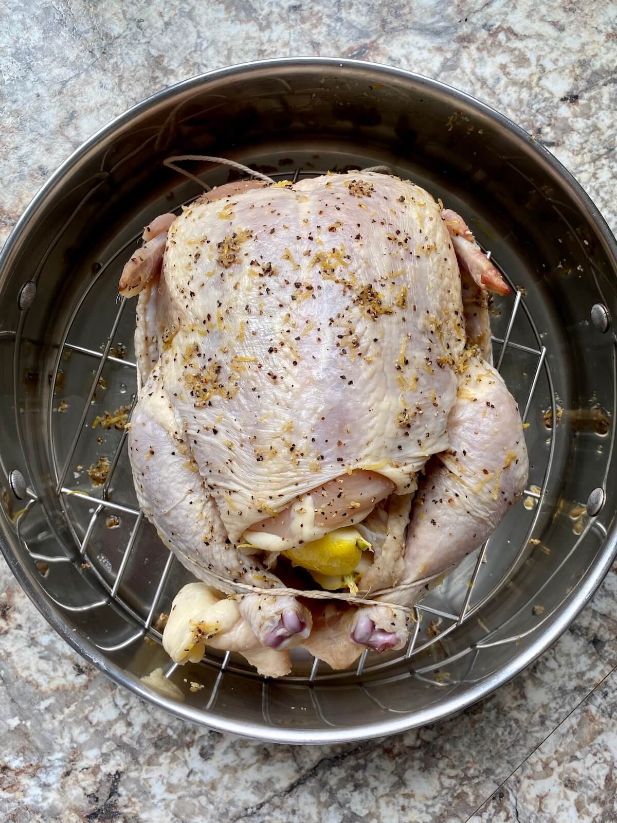 A dry brined chicken stuffed with aromatics and trussed before roasting.