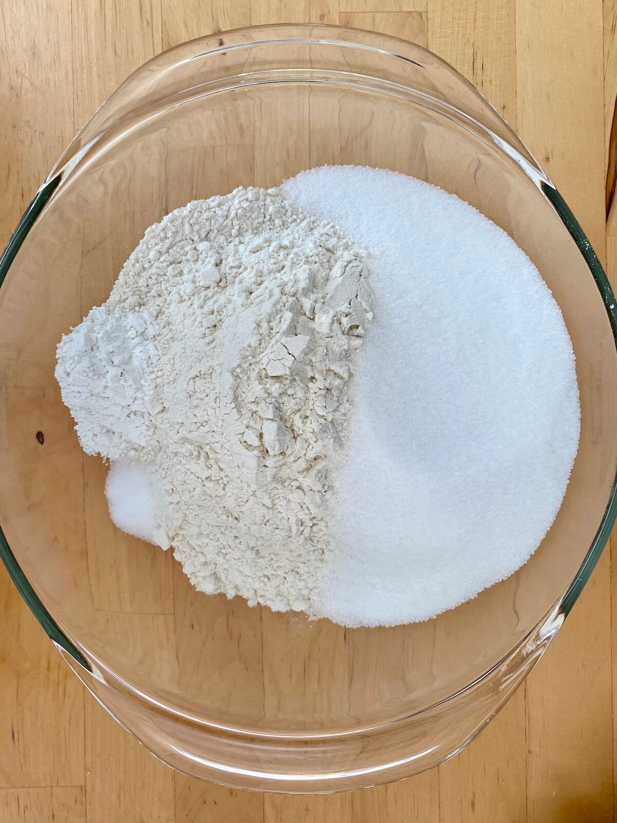 Flour, sugar, baking powder, and salt in a clear glass bowl.