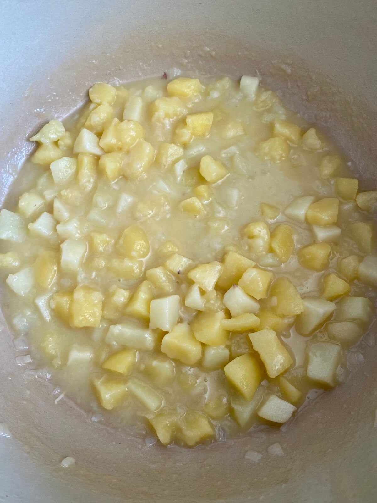 Cooked potatoes in starchy water in a large dutch oven.