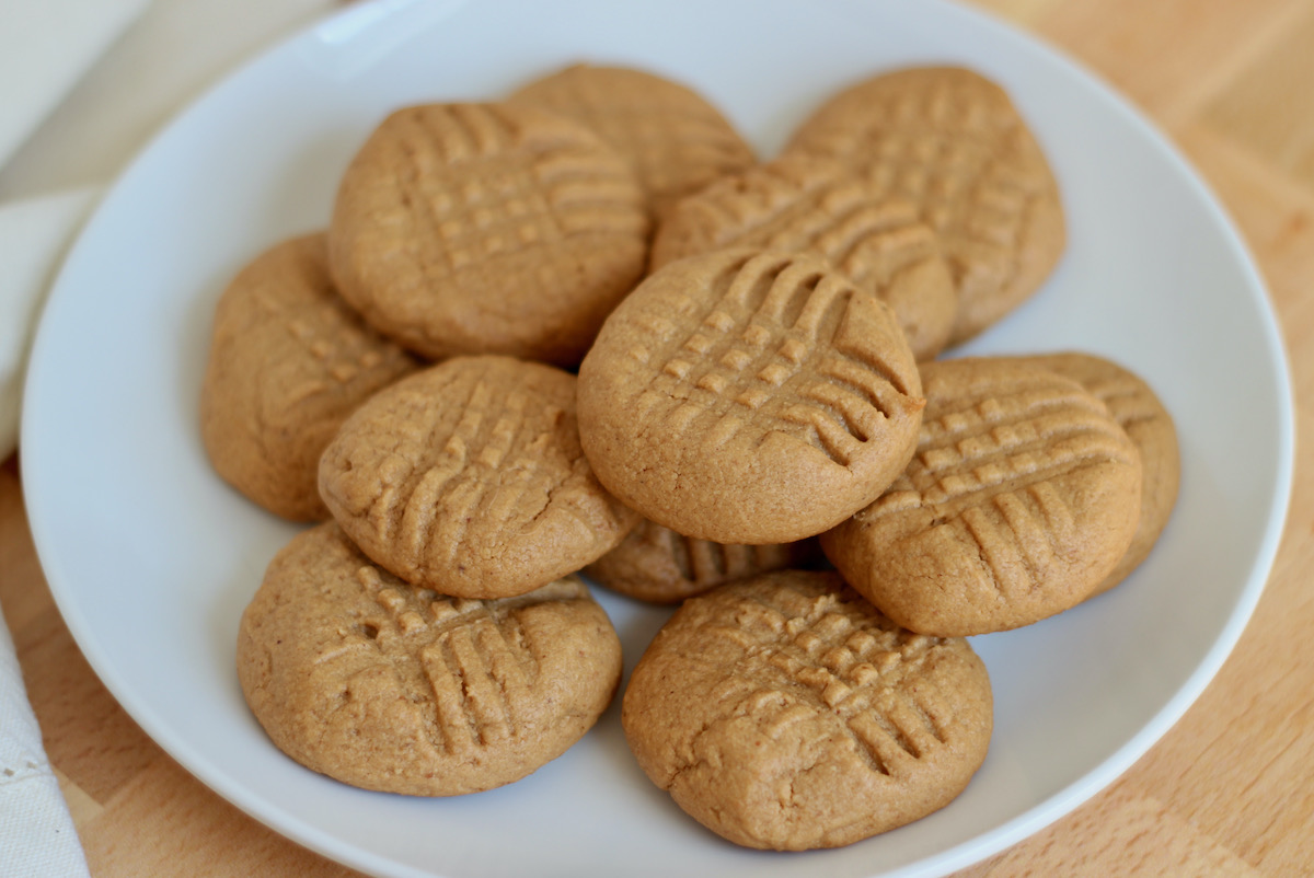 A small white plate of 2 ingredient peanut butter cookies.