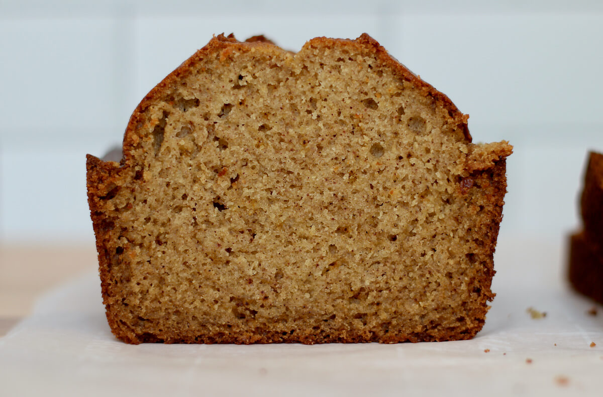 A loaf of acorn squash bread sliced in half so you can see the texture of the crumb.