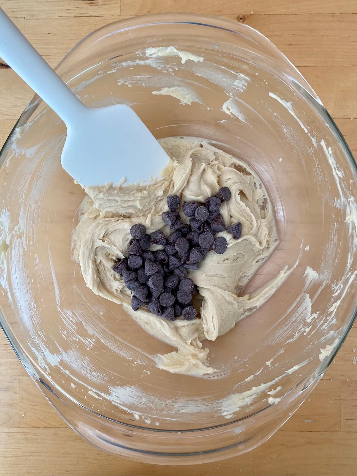 The chocolate chip cookie dough in a glass mixing bowl.