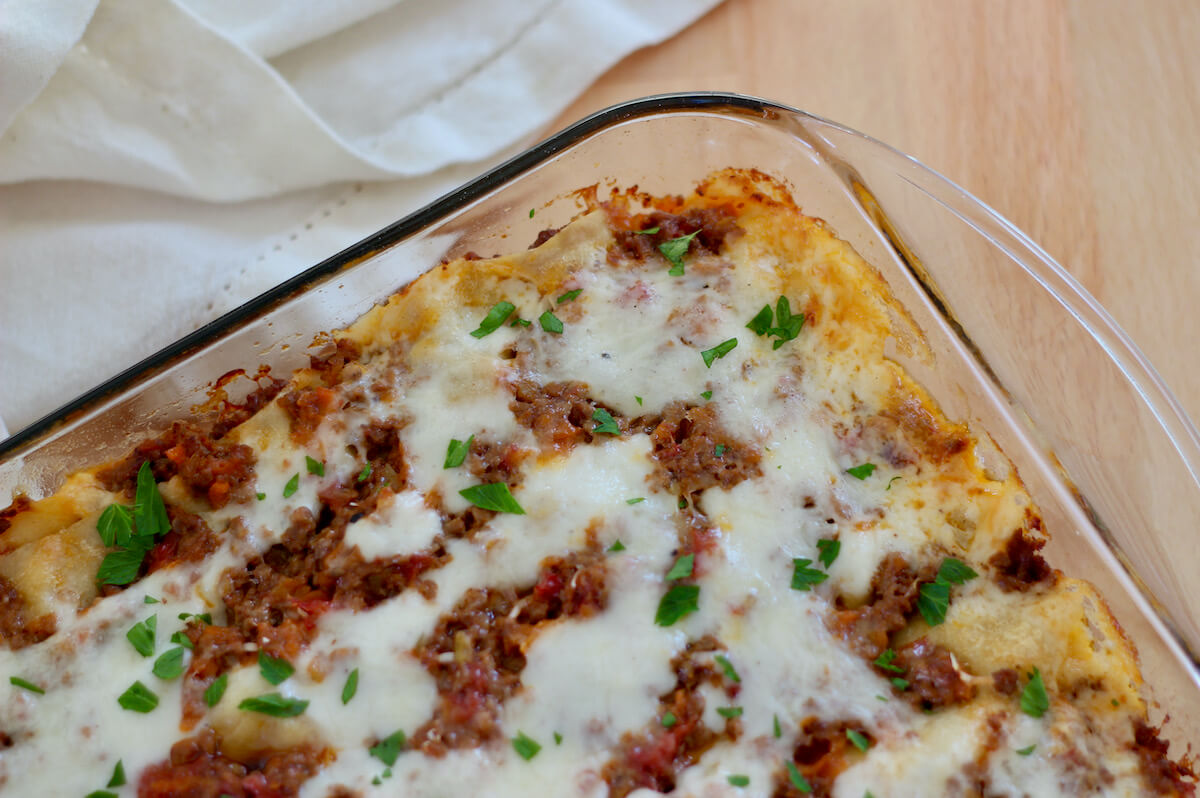 A glass baking dish filled with cooked lasagna al forno.