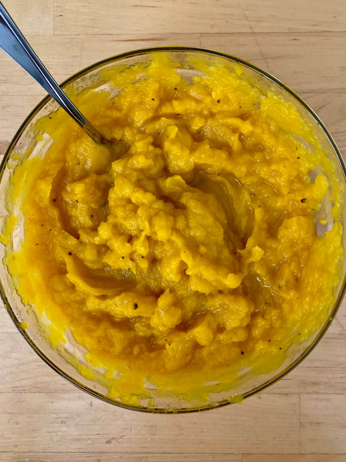 A glass bowl filled with homemade roasted pumpkin puree.