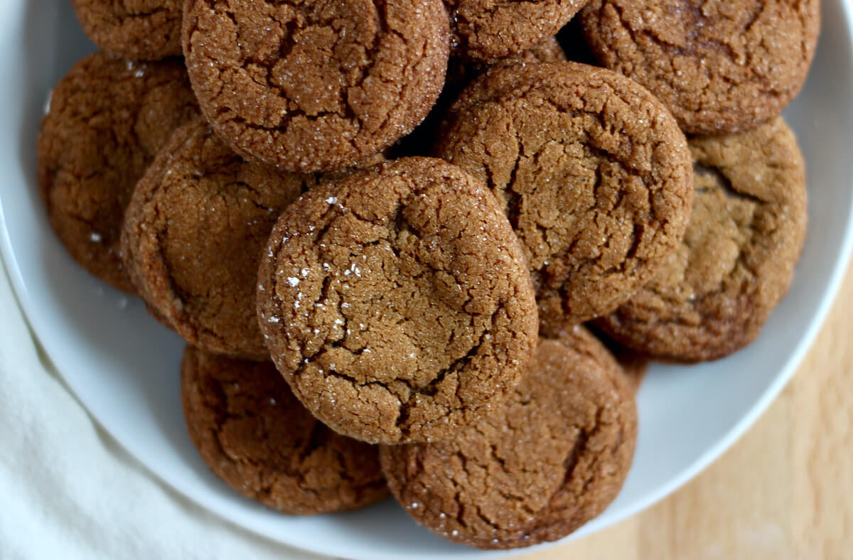A small white plate filled with molasses crinkle cookies.