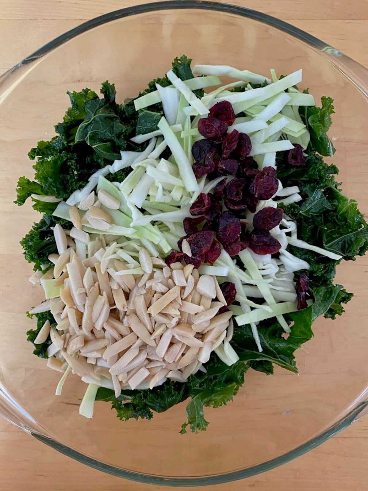All of the salad ingredients in a glass mixing bowl.