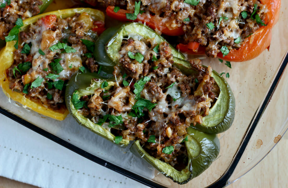 A casserole dish filled with stuffed peppers without tomato sauce.
