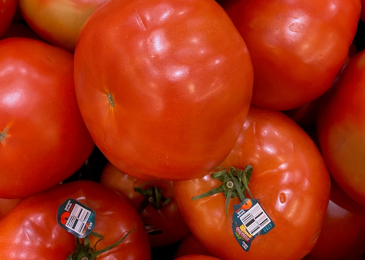 Large beefsteak tomatoes on the shelf at the grocery store.