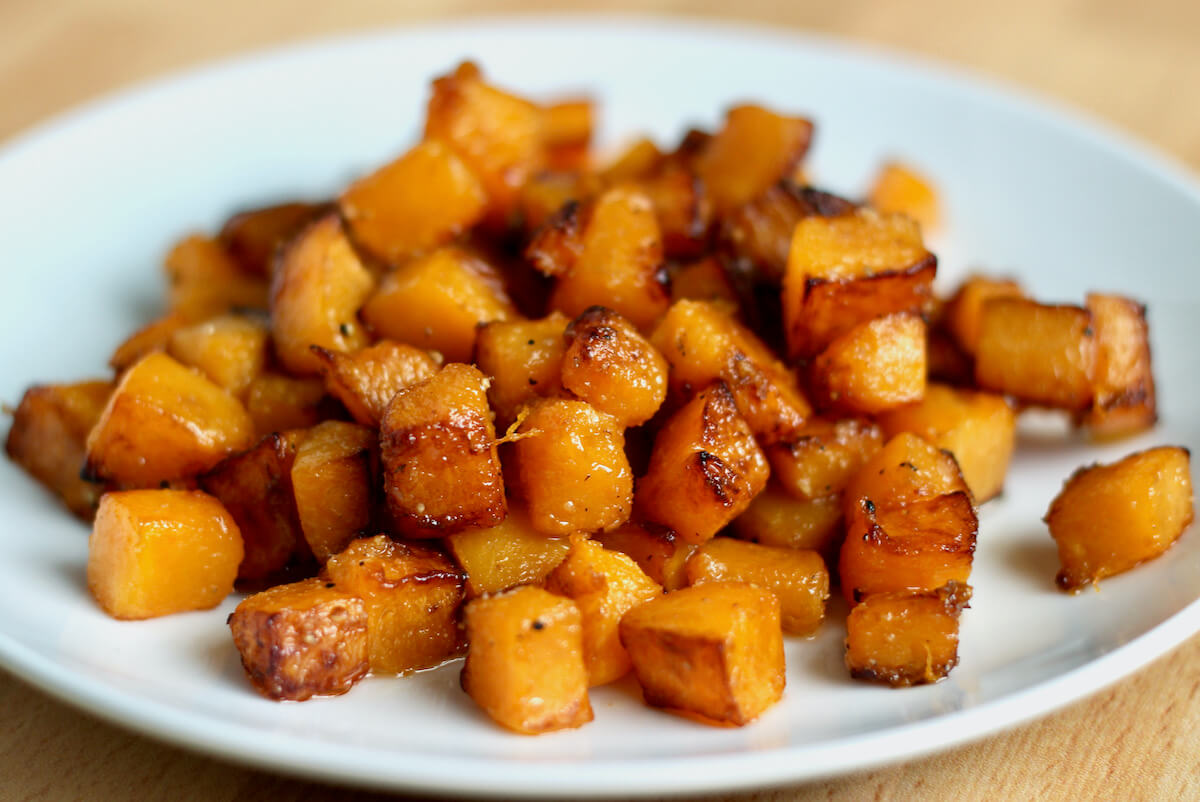 A small white plate filled with pan-fried butternut squash.