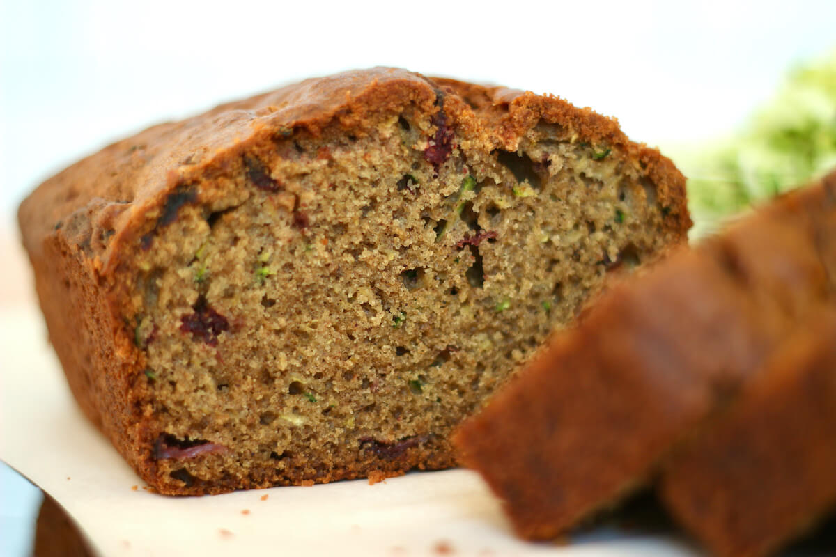 A loaf of strawberry zucchini bread cut so you can see the texture and crumb.