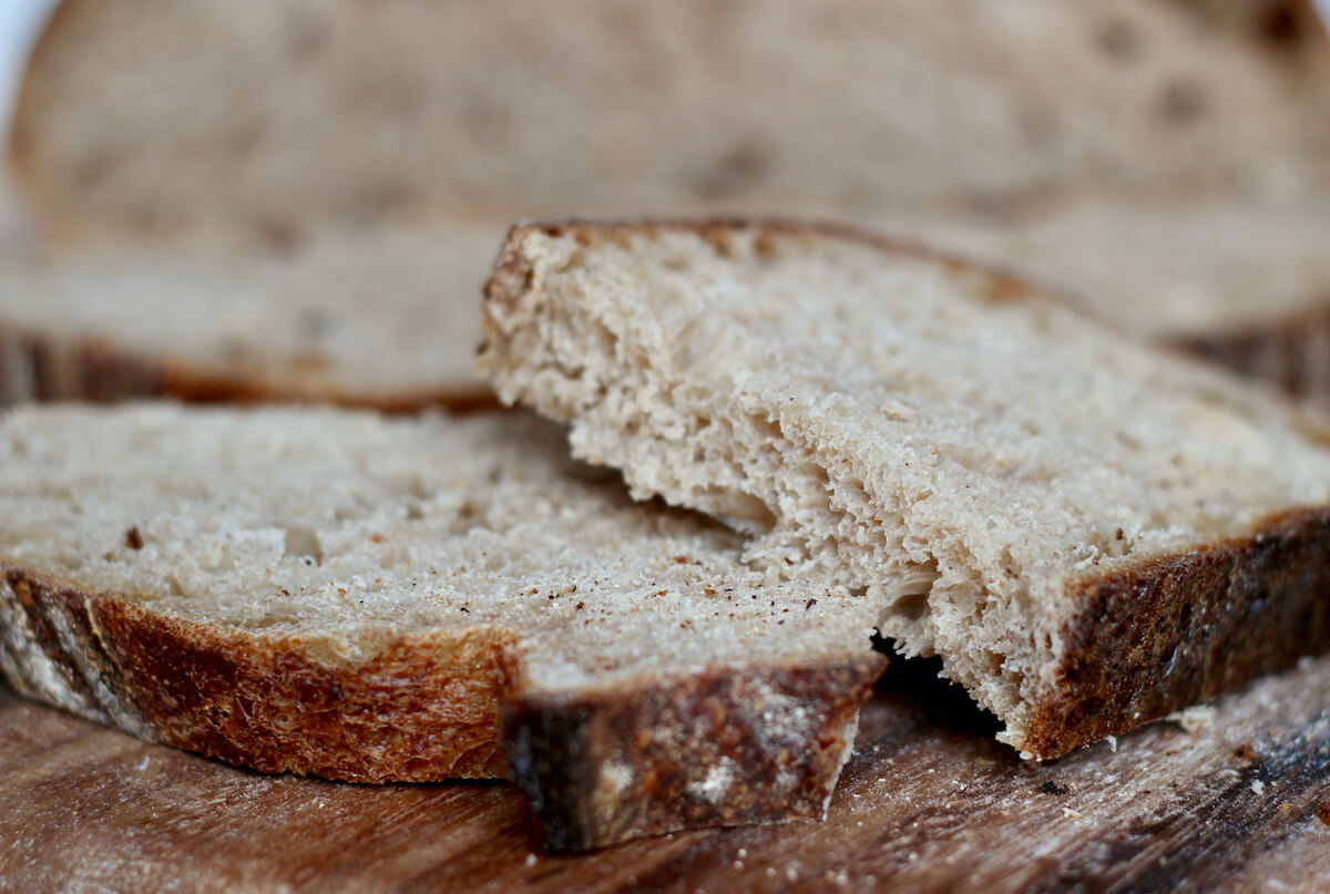 Two slices of sourdough bread on a wooden bread peel.