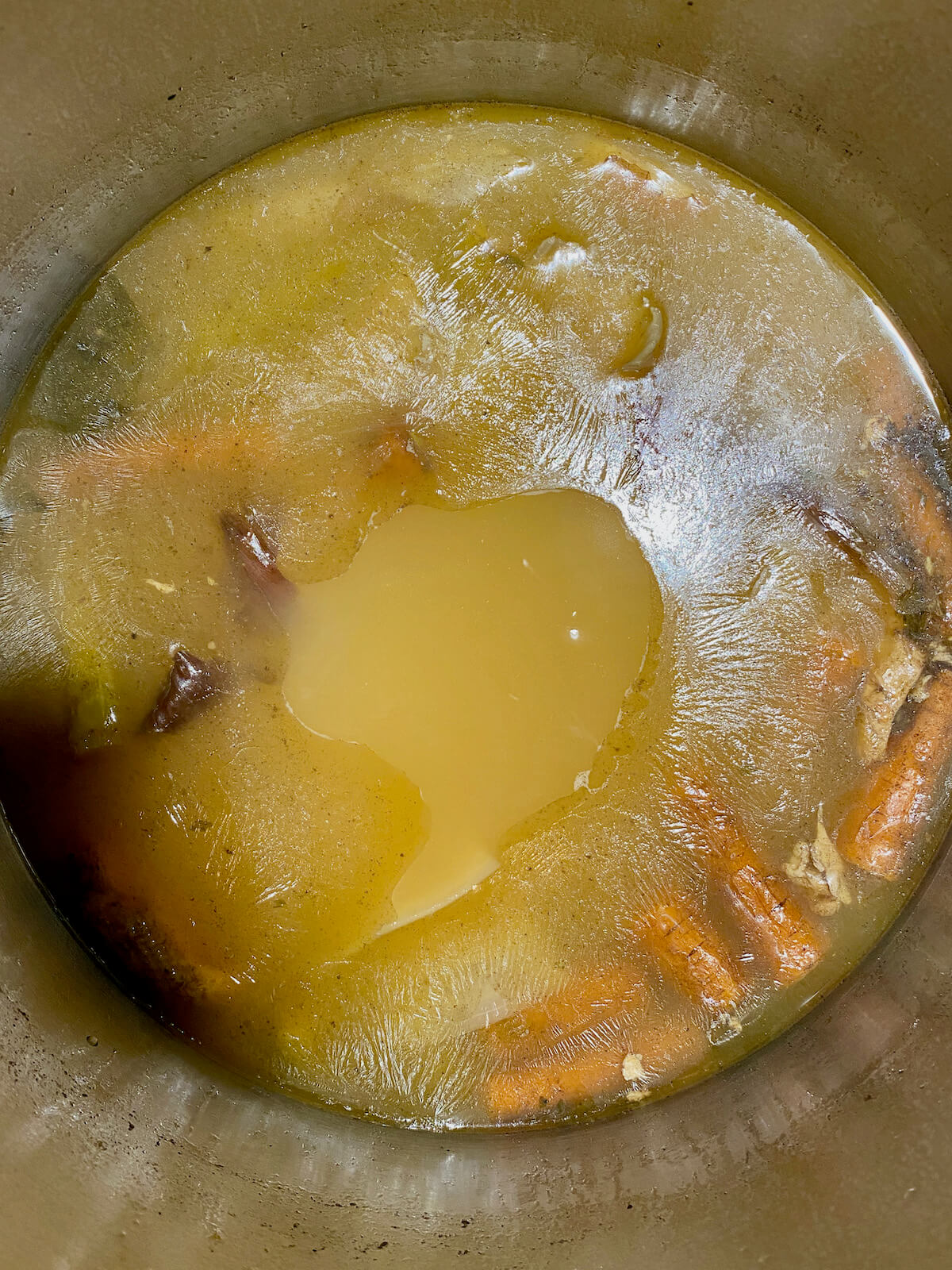 The finished chicken bone broth in a large stock pot before being strained.