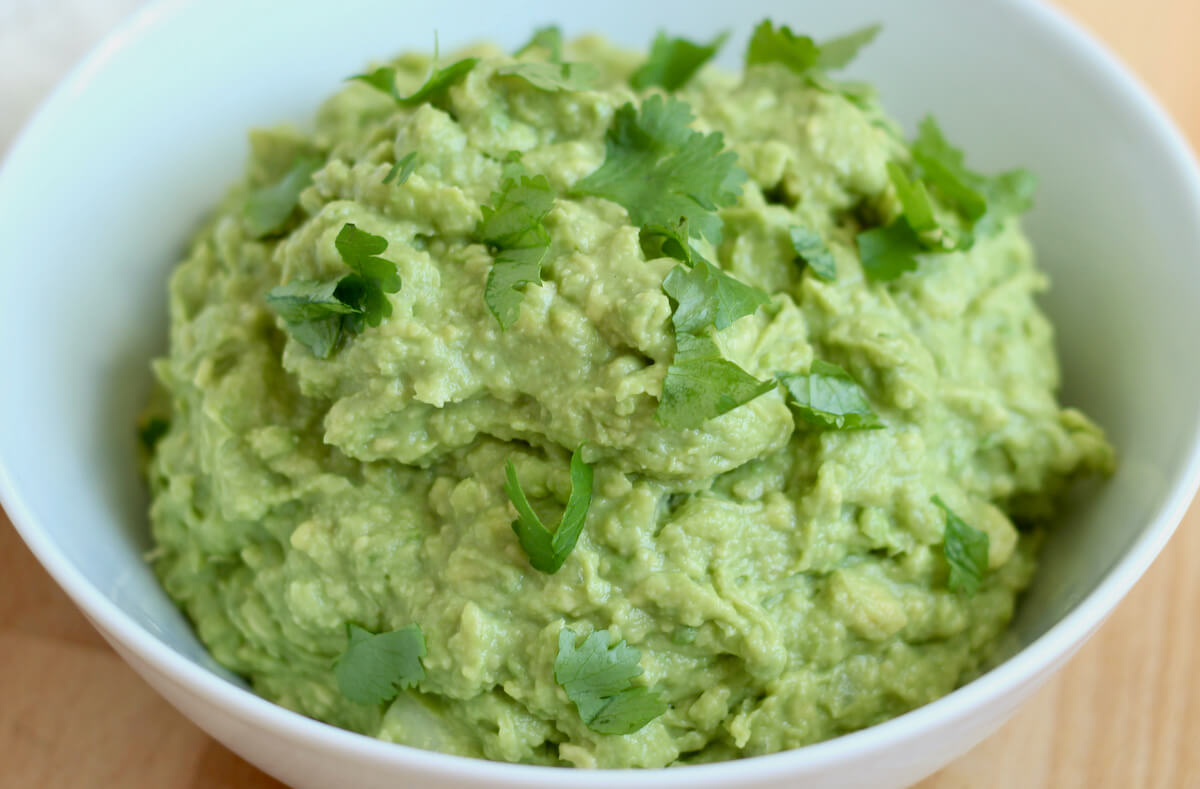 A white bowl filled with 4-ingredient guacamole.