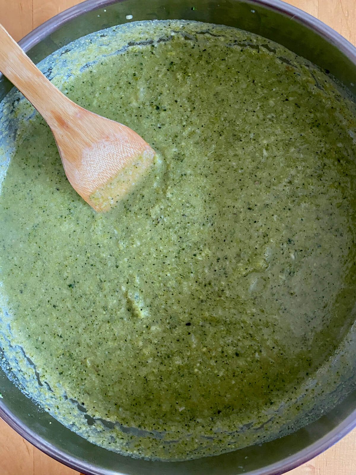 The puréed broccoli and asparagus soup in a stainless steel pot.