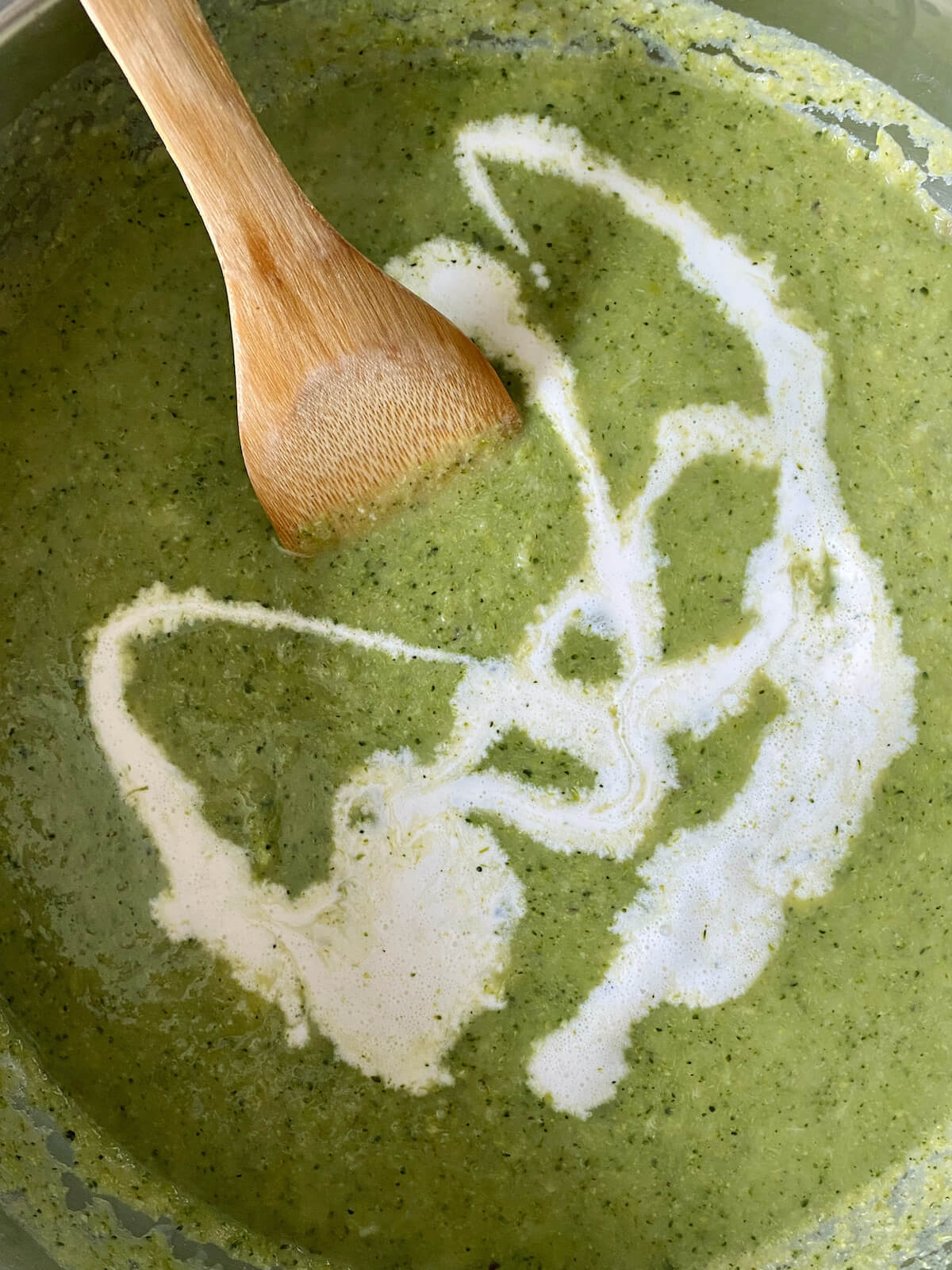 Heavy cream being added to the puréed soup.