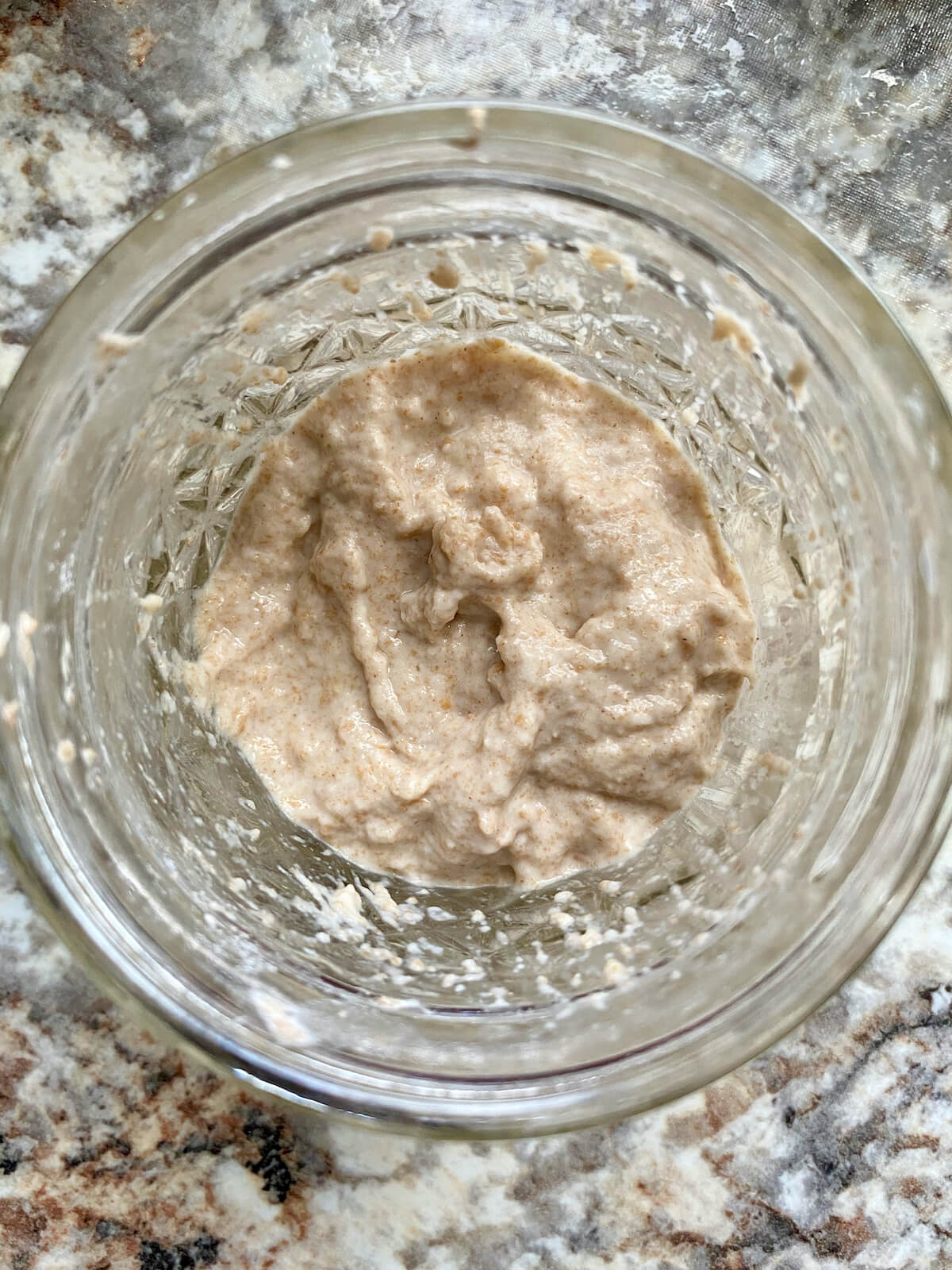 Sourdough starter in a small glass jar after being fed.