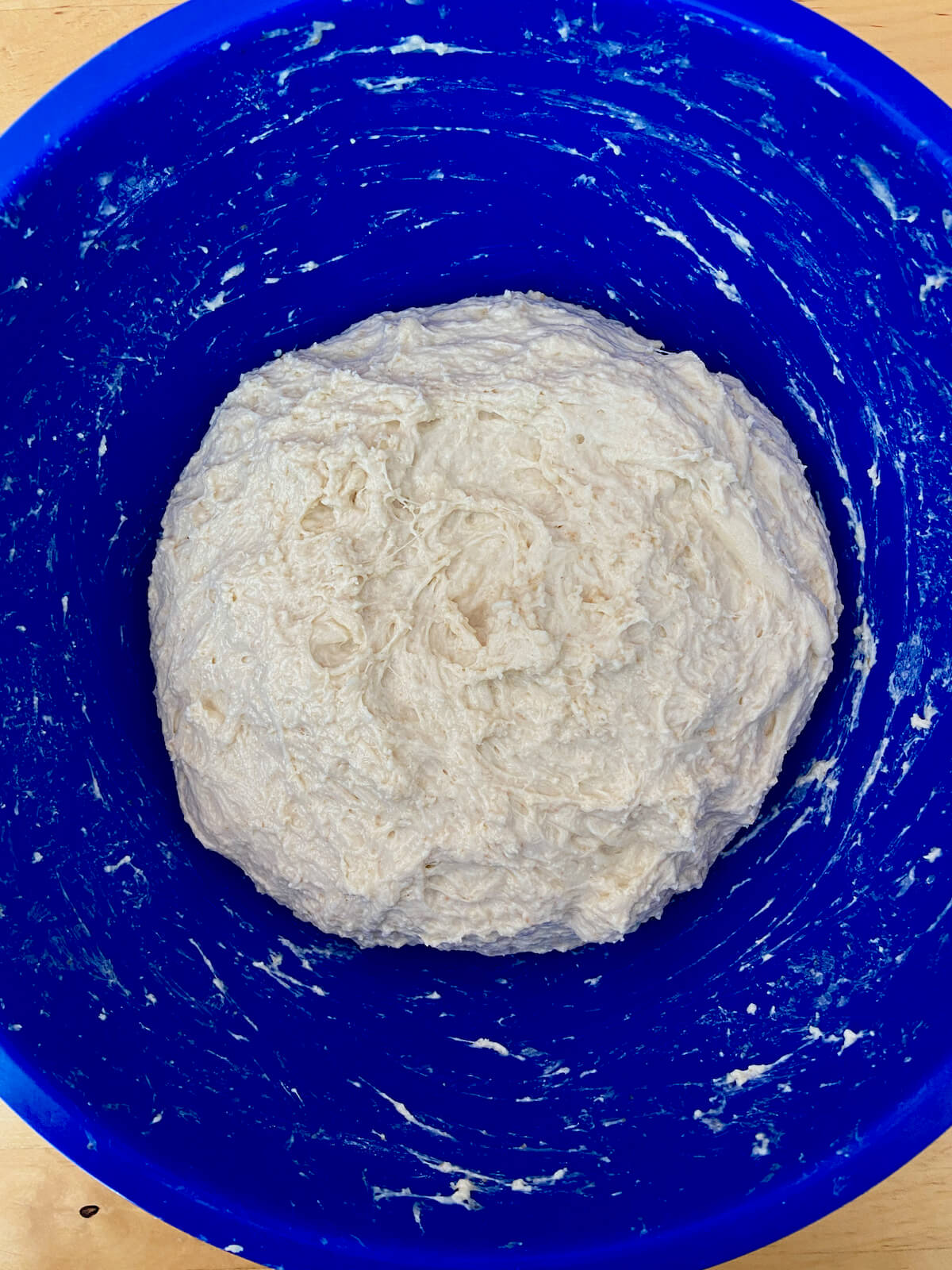 The mixed dough in a blue mixing bowl.