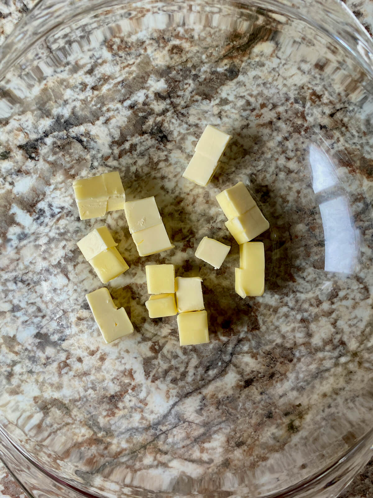 Cubed butter in a glass bowl.