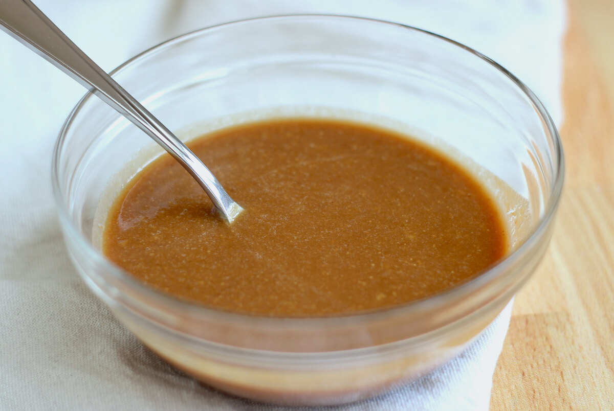 Peanut butter salad dressing in a clear glass bowl.