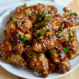 Soy garlic chicken wings on a small white plate.