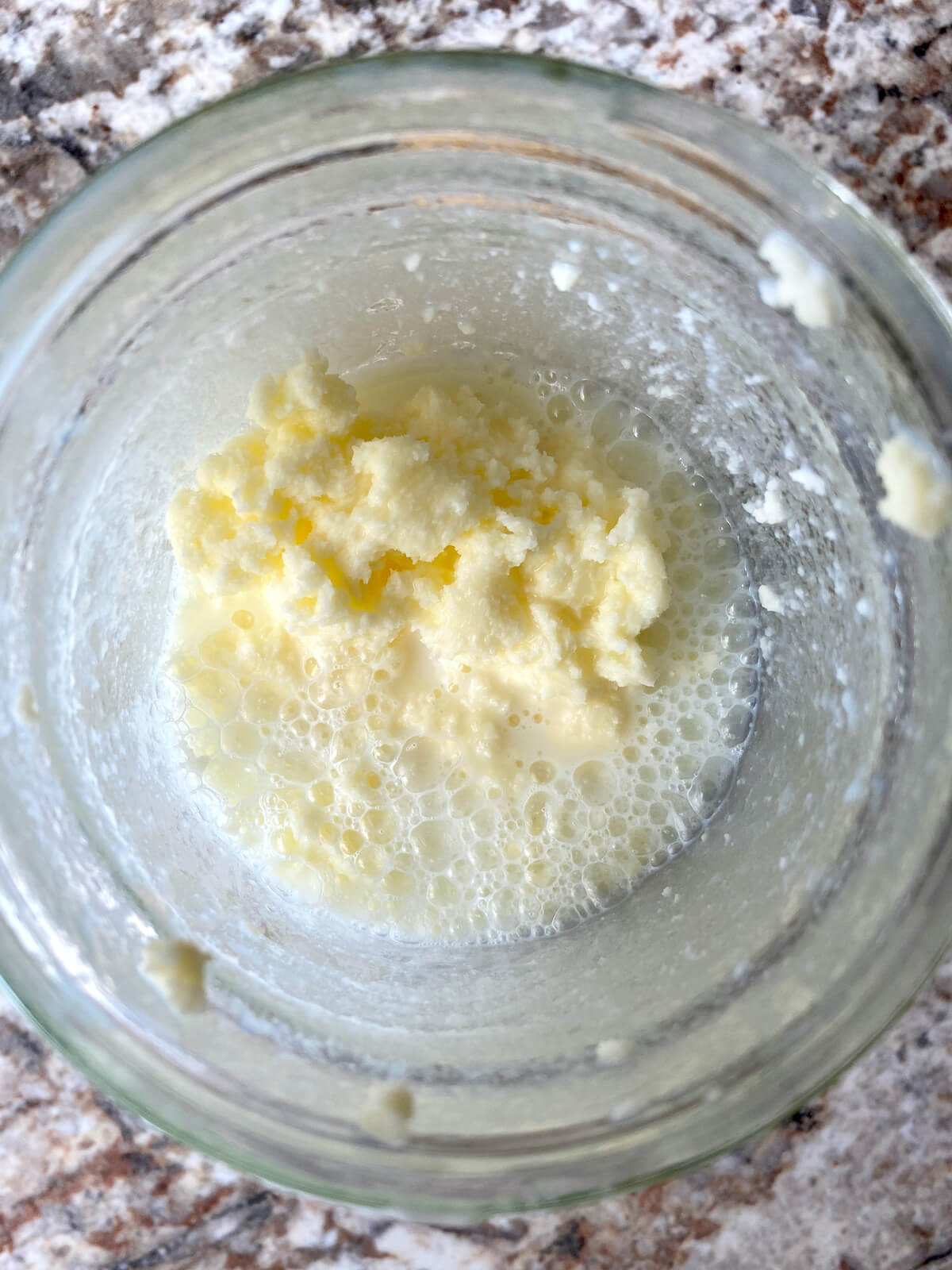 The heavy cream separated into butter and buttermilk in a glass mason jar.