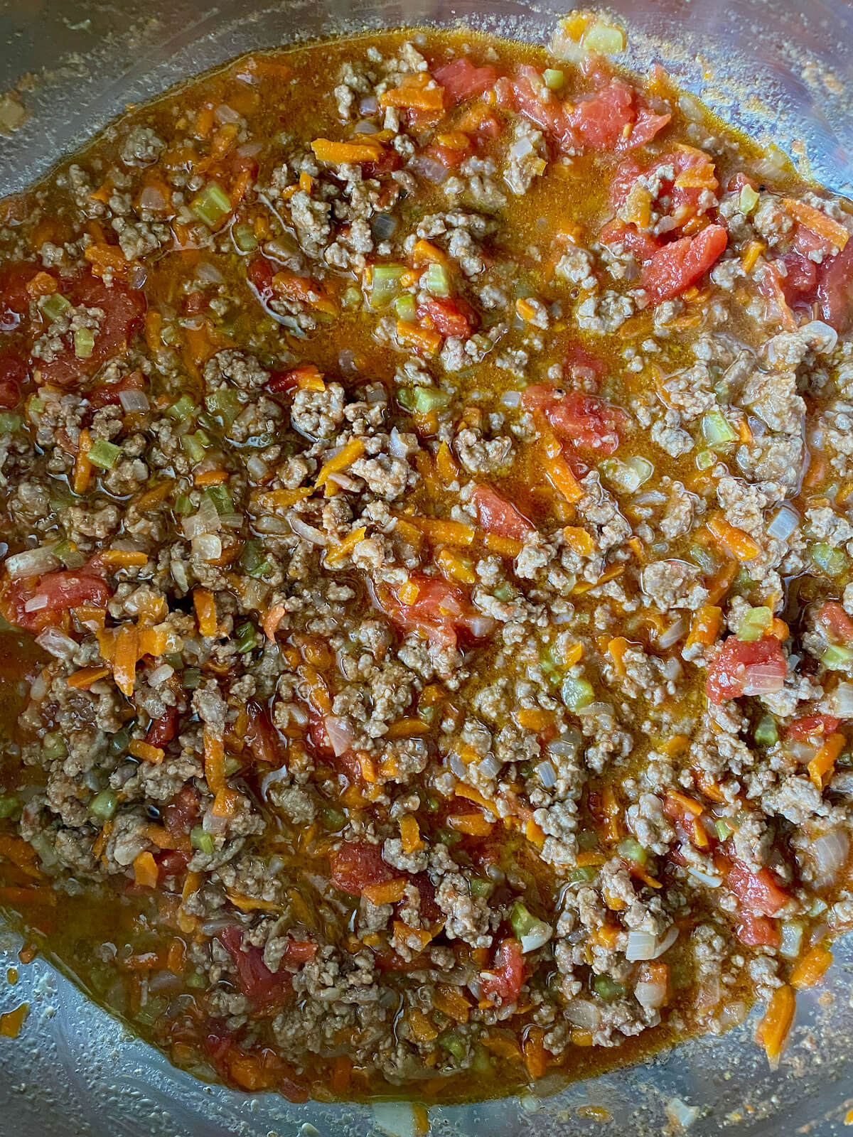 The bolognese sauce simmering after the San Marzano tomatoes have been broken up into smaller pieces.