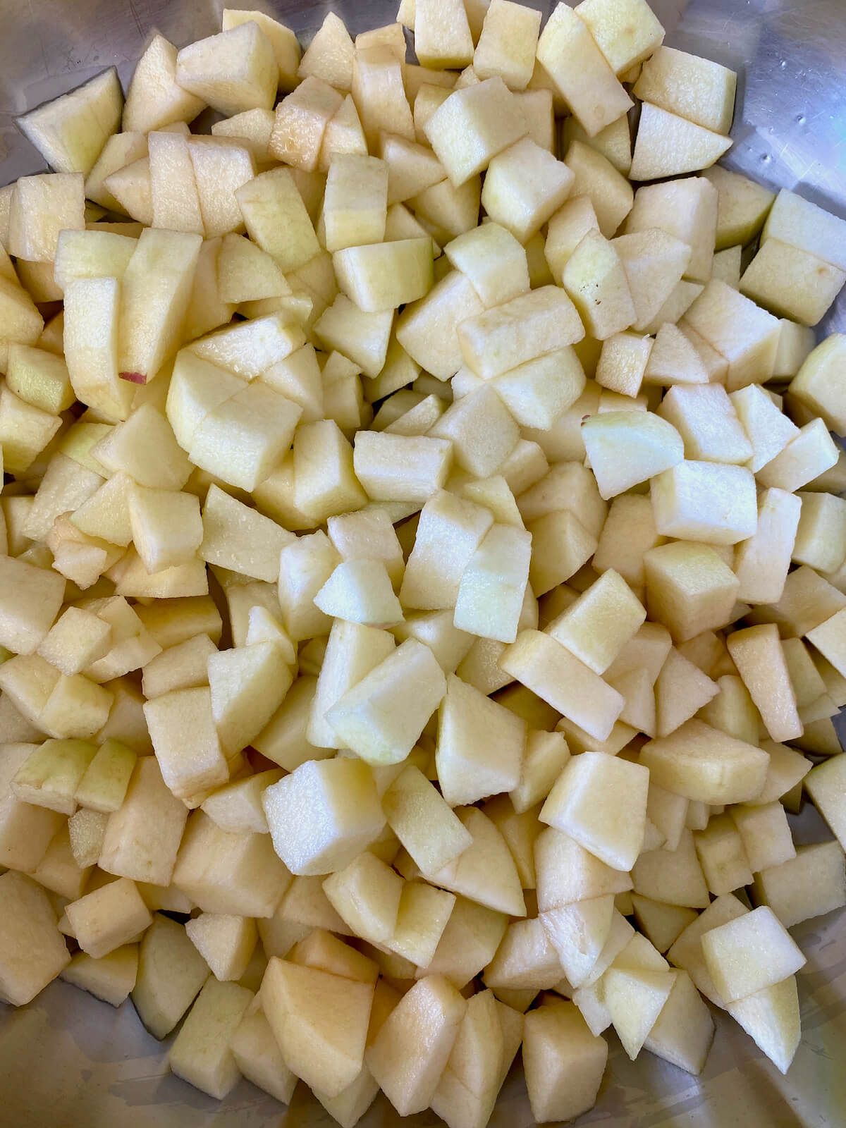 Diced apples, water, and lemon juice in a stainless steel pot.