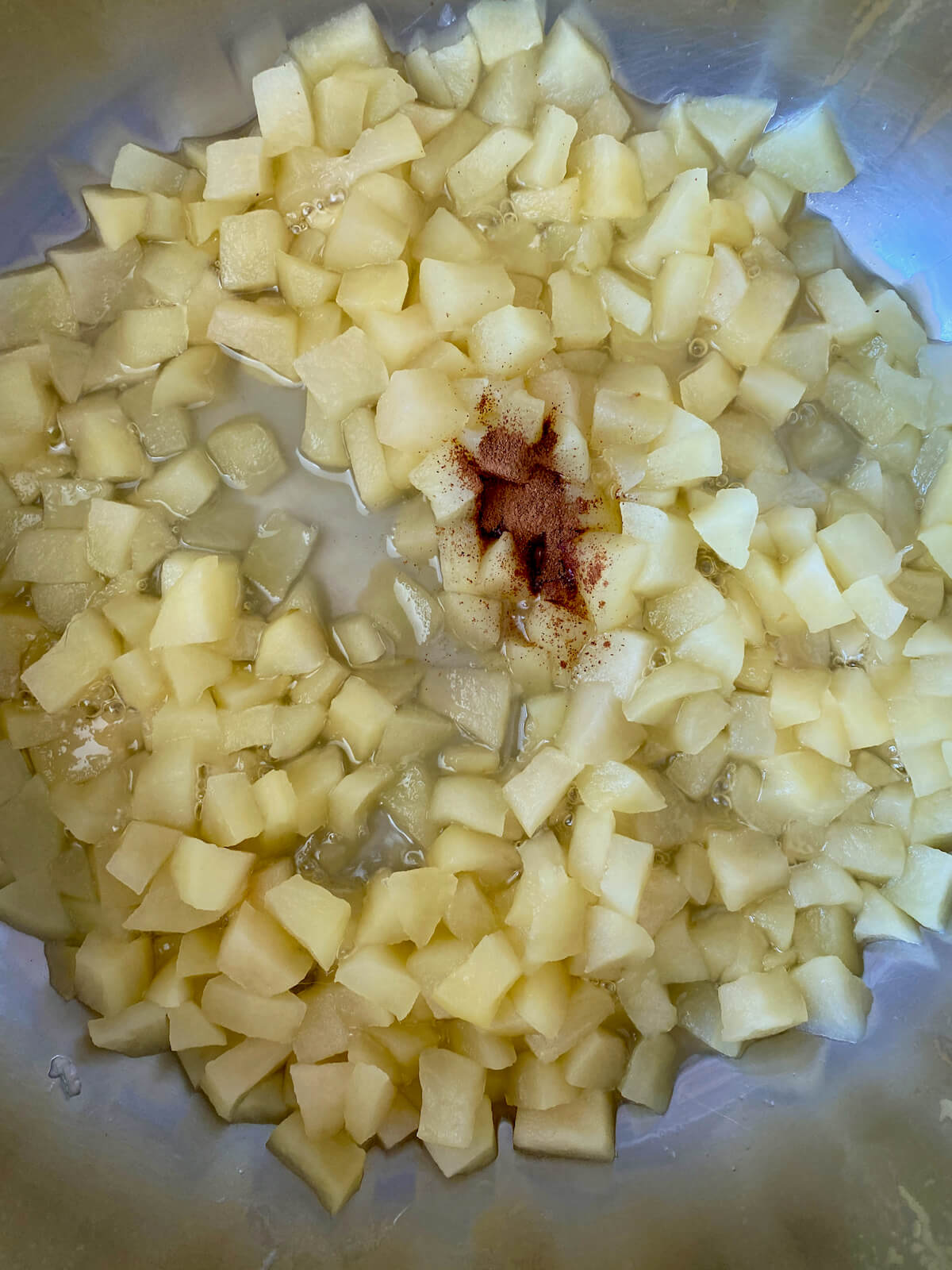 Cooked apples with cinnamon sprinkled on top.