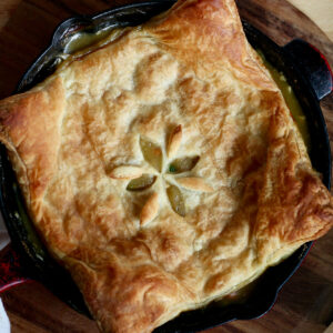 Turkey pot pie with puff pastry in a cast iron skillet.