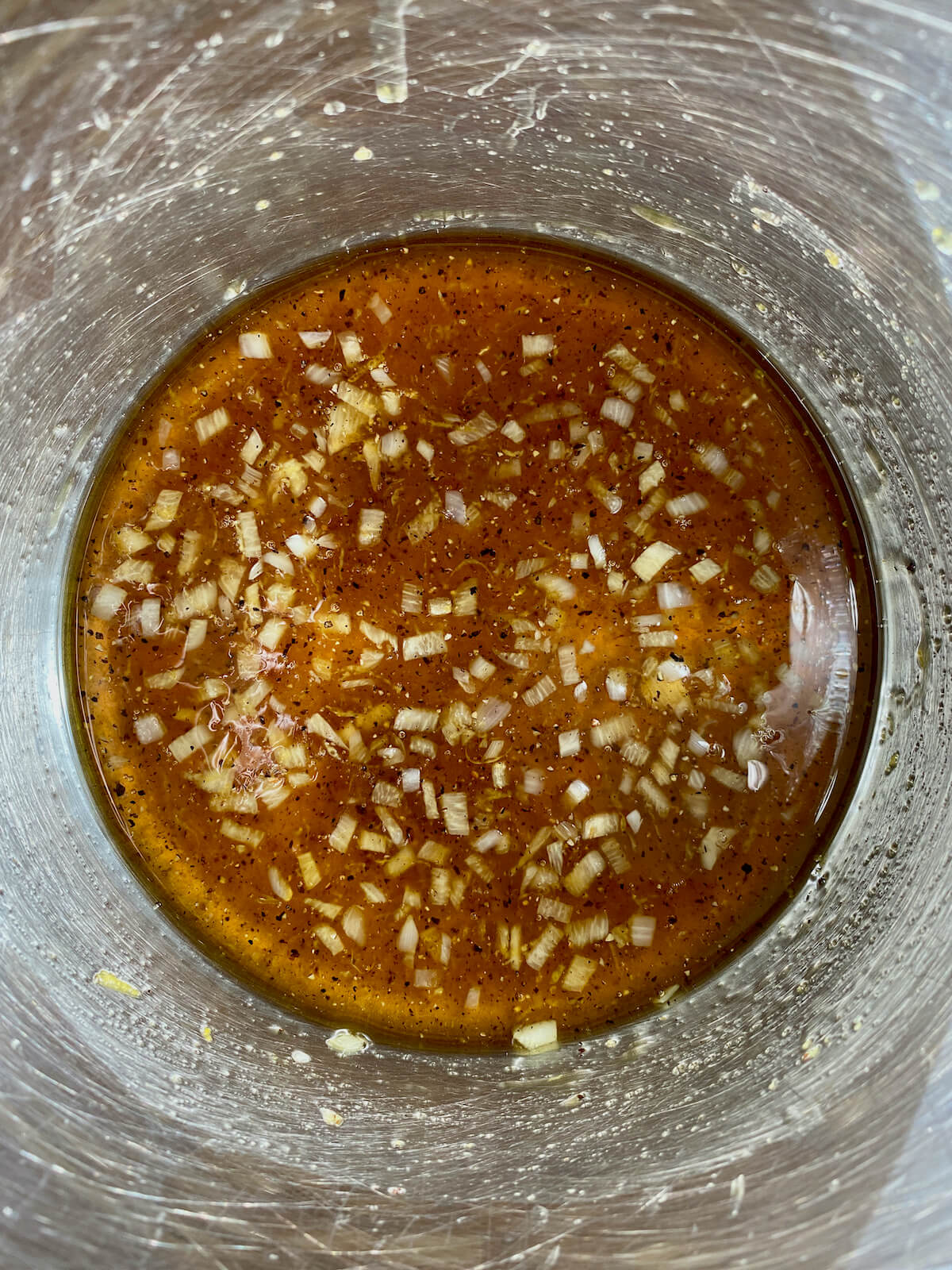 Honey lemon pepper glaze simmering in a stainless steel pot.