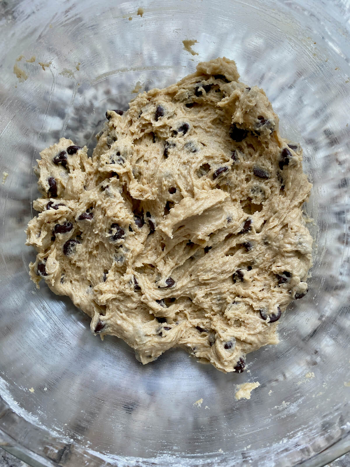 Sourdough chocolate chip cookie dough in a glass mixing bowl.