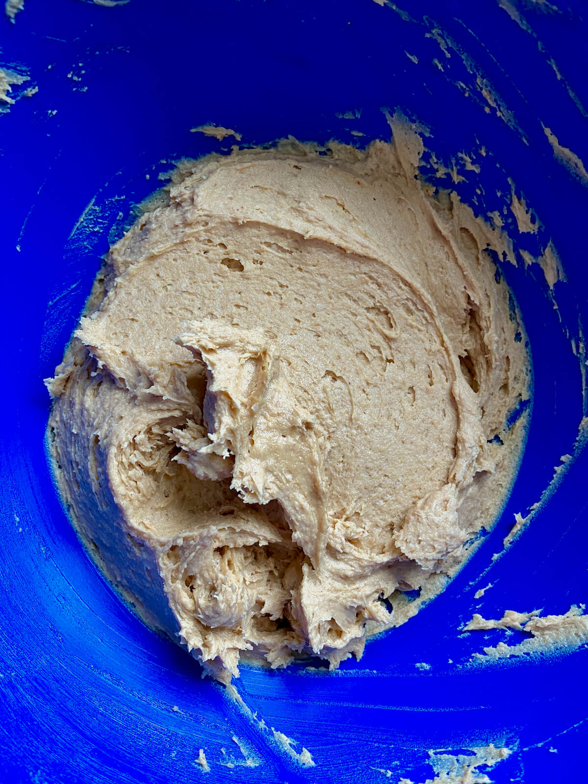 The sourdough peanut butter cookie dough in a blue mixing bowl.