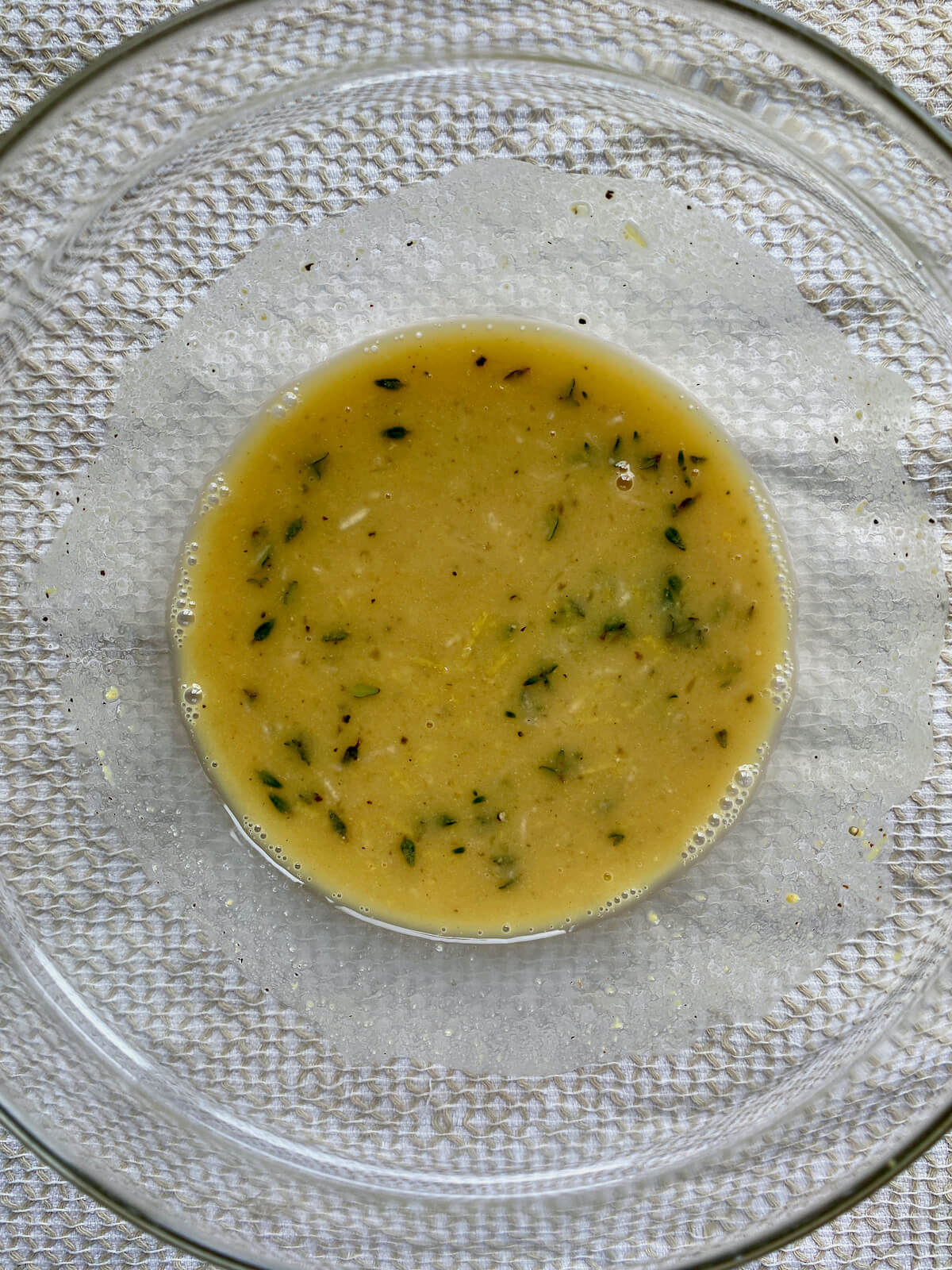 The dressing ingredients whisked together in a small glass bowl before adding olive oil.