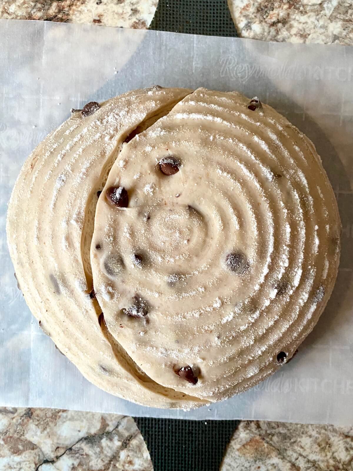 The scored dough on a piece of parchment paper, ready to be baked.