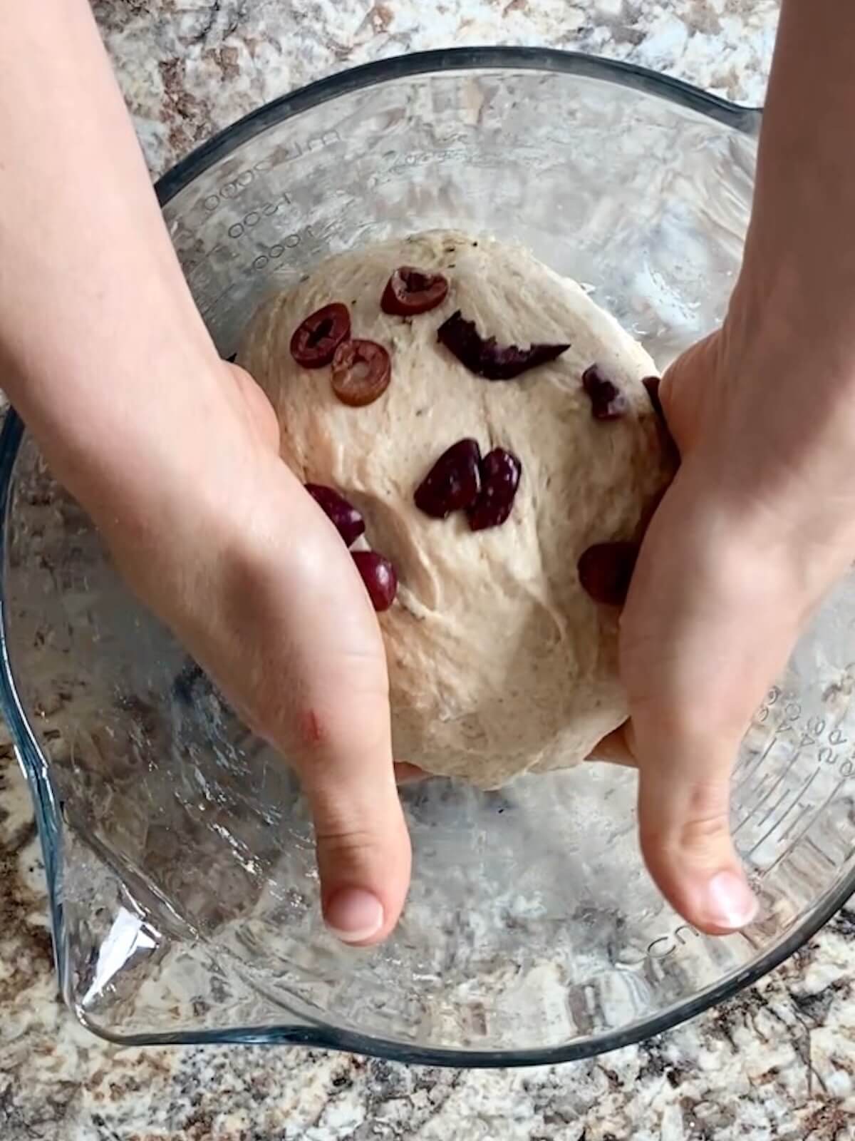 The dough gathered into a ball being placed seam side down into the mixing bowl.