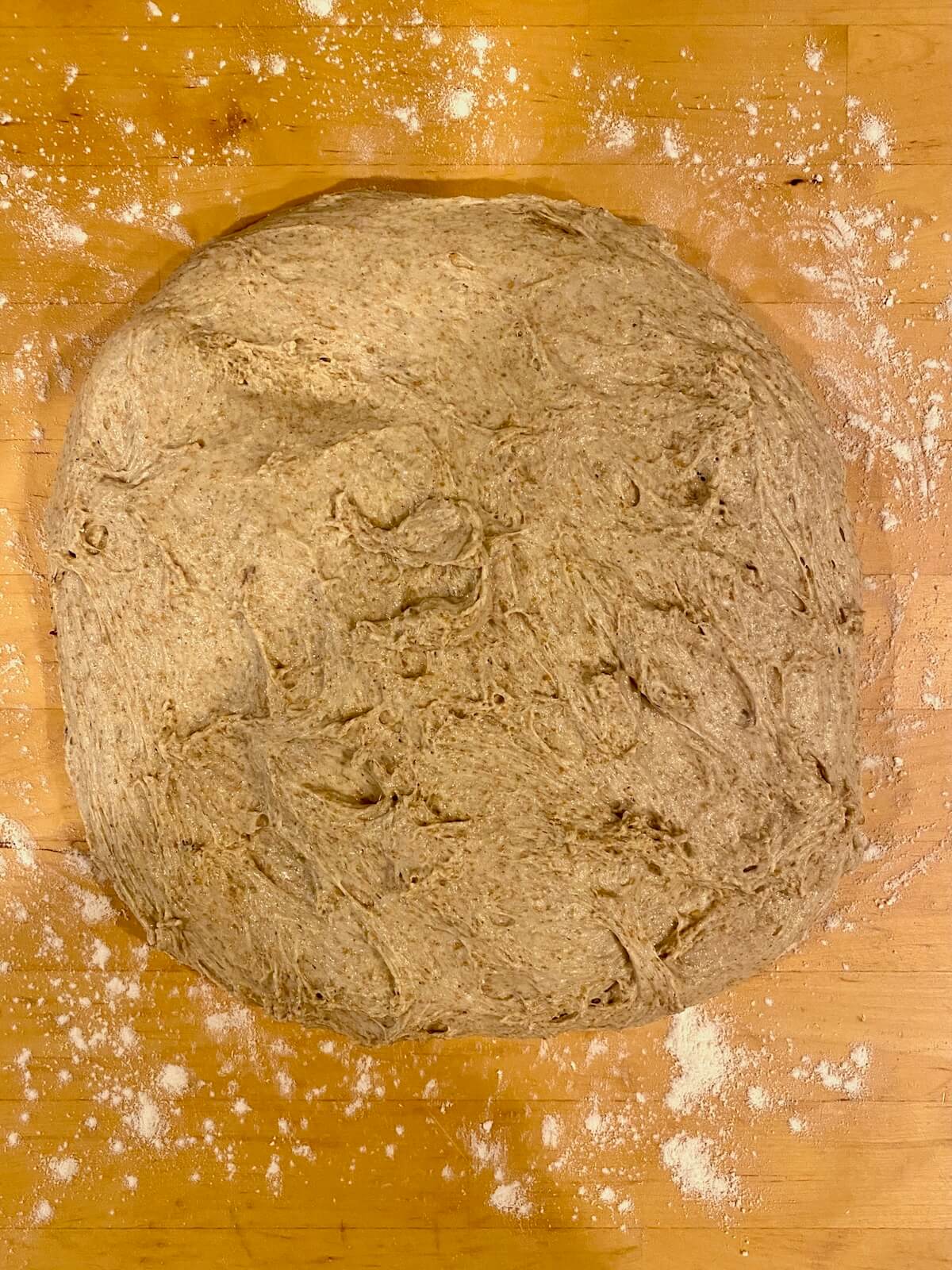 The dough stretched out into a rectangle on a lightly floured wooden countertop.