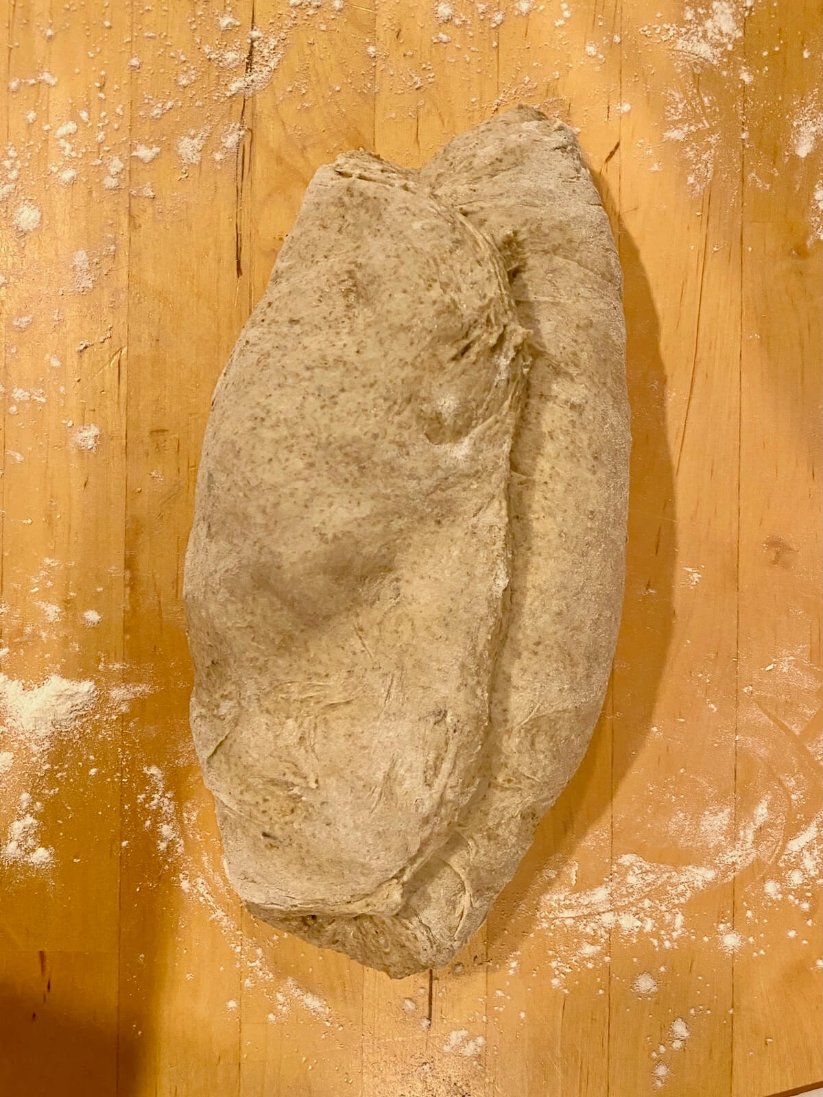 The dough folded over itself like a letter on a lightly floured wooden counter top.