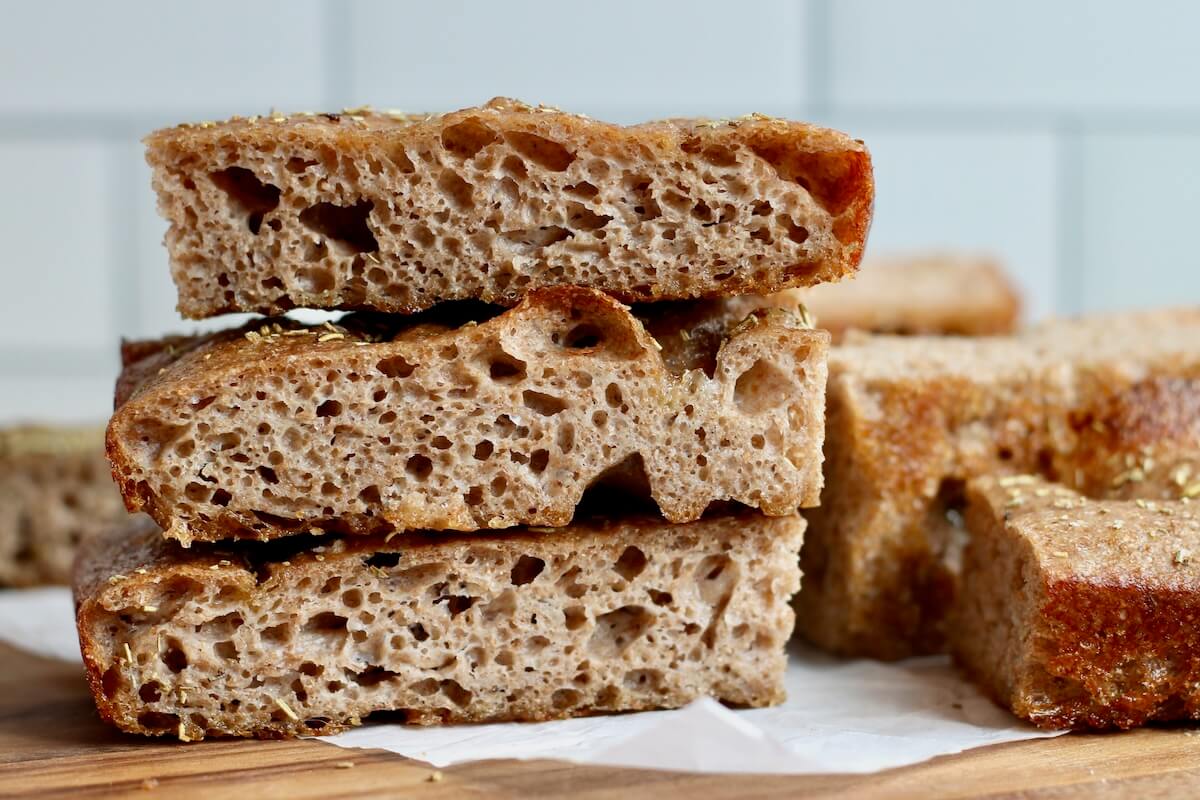 Three pieces of whole wheat sourdough focaccia stacked on top of each other.