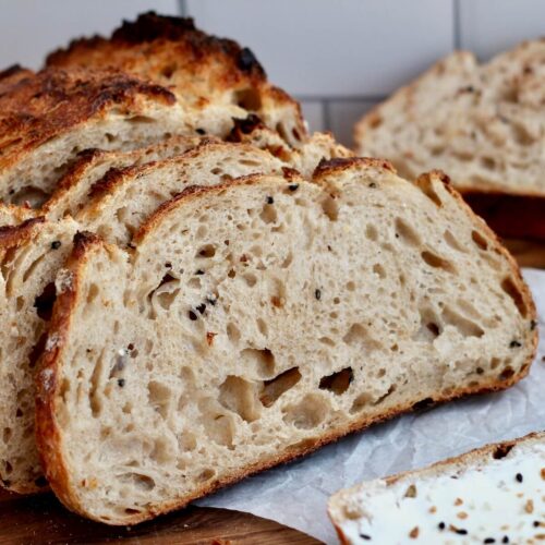 A loaf of everything bagel sourdough bread cut into slices.
