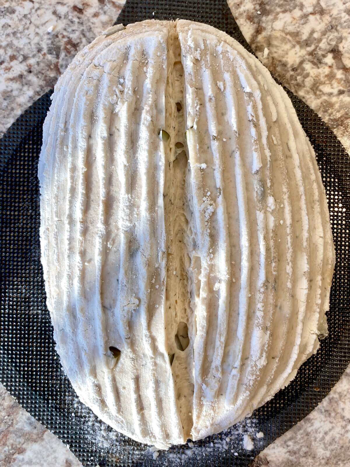The dough scored on a bread sling before baking.