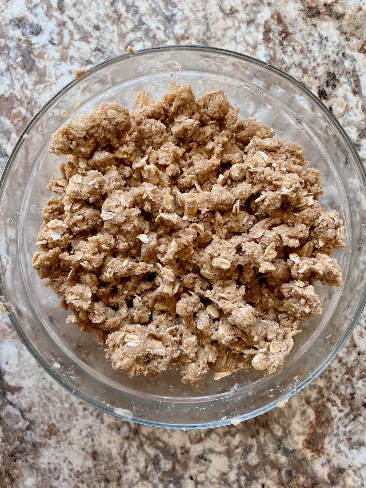 Sourdough oat crumble topping for the apple crisp in a small glass bowl.