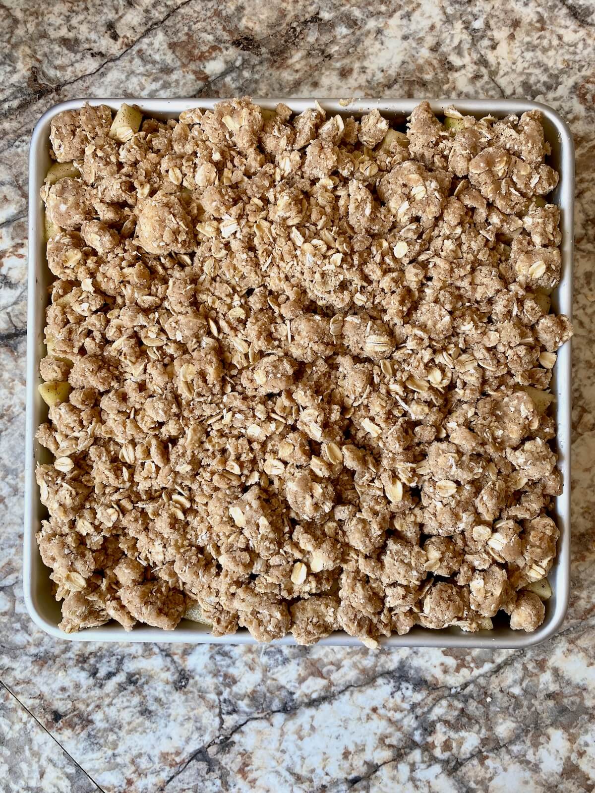 Sourdough apple crisp in a square baking pan before baking.
