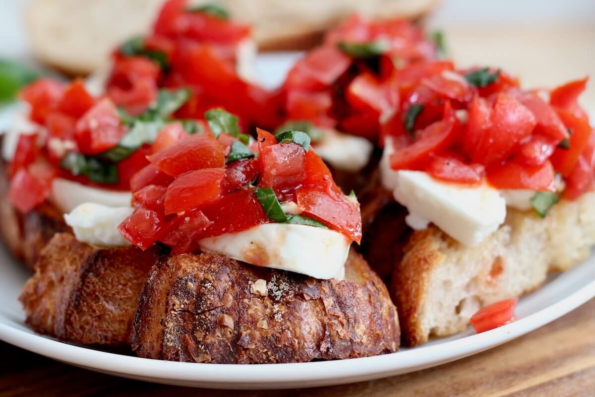 Pieces of sourdough bruschetta on a small white plate.