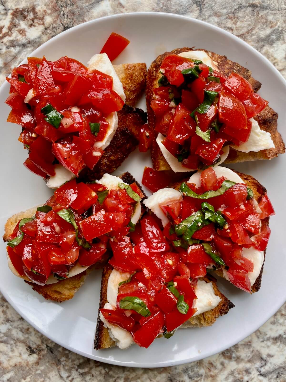 The assembled sourdough bruschetta on a small white plate.