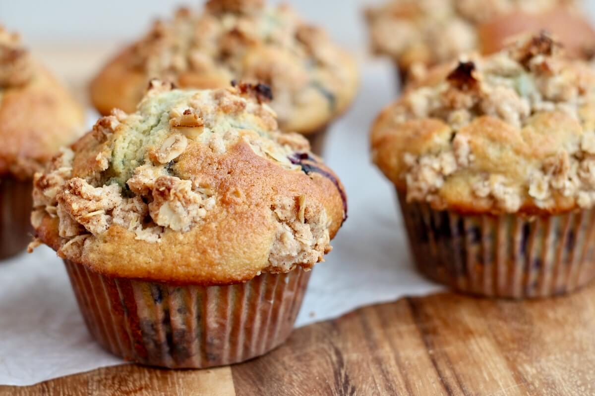 Several sourdough discard blueberry muffins with crumb topping.