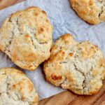 Sourdough drop biscuits on a piece of wrinkled parchment paper.