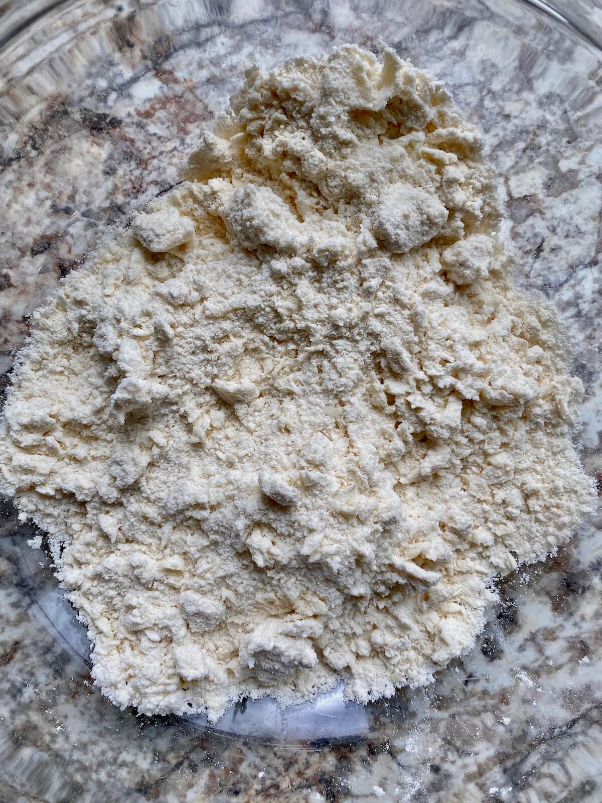 Butter cut into flour in a glass bowl.