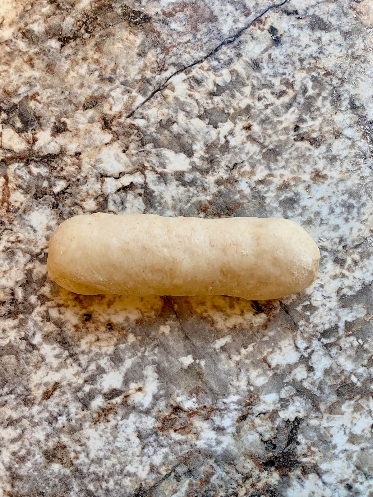 A piece of dough shaped like a hot dog bun.